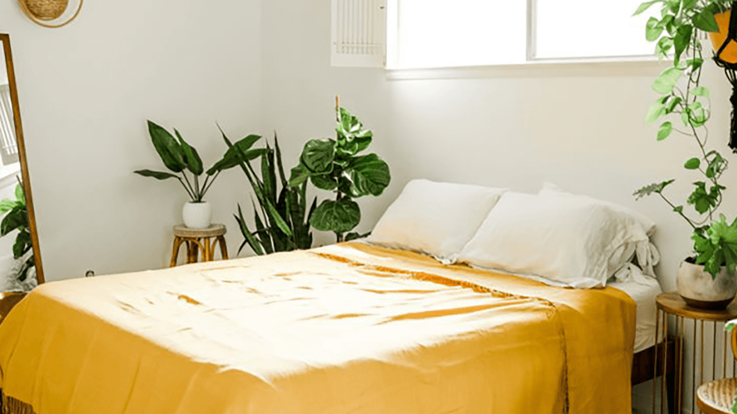 Yellow linen bedding in room with plants Jungle Pillows Homepage Banner